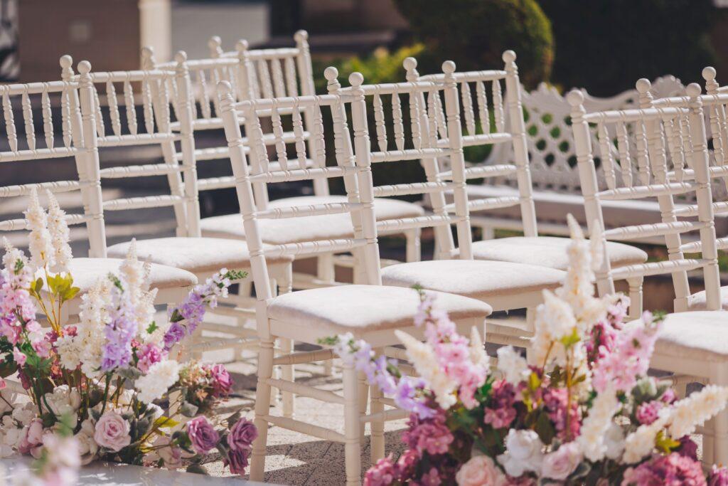 Elegante weiße Stühle mit Blumendekorationen