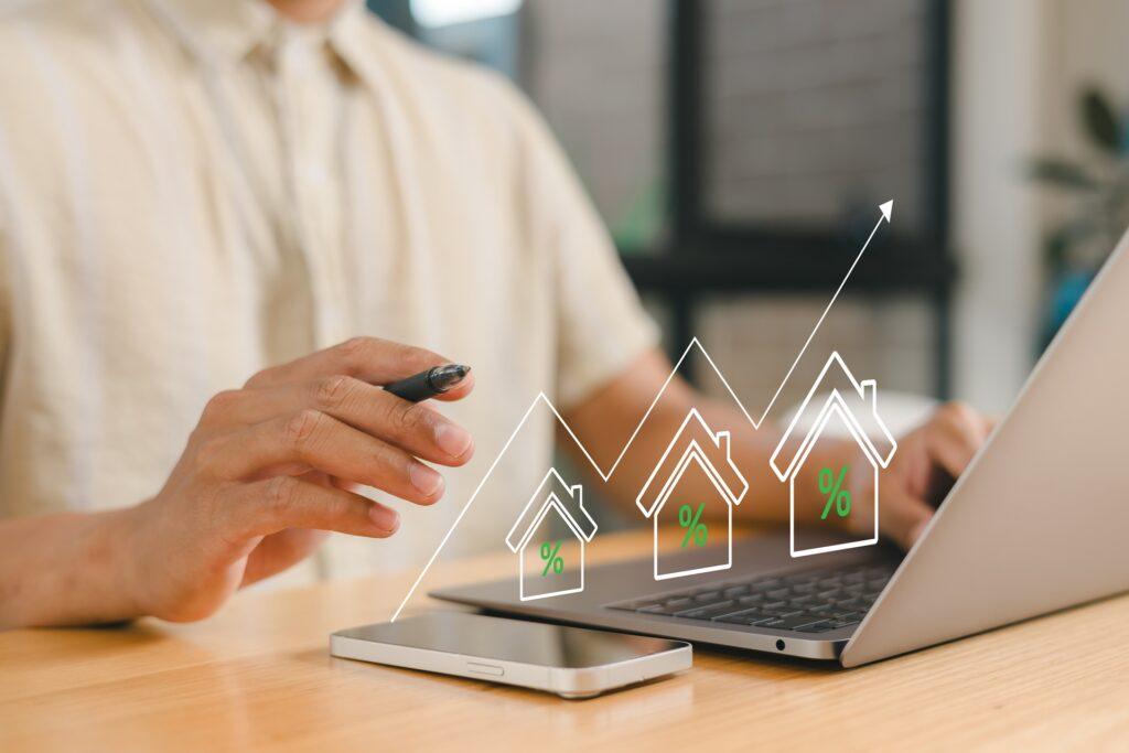 Person analysiert steigende Immobilienwerte am Laptop | GFK Pool