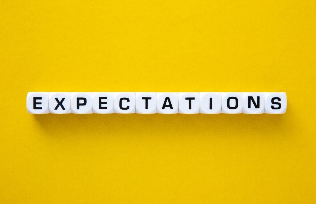 Würfel mit Buchstaben bilden das Wort Expectations auf Gelb | Baufinanzierung Mönchengladbach
